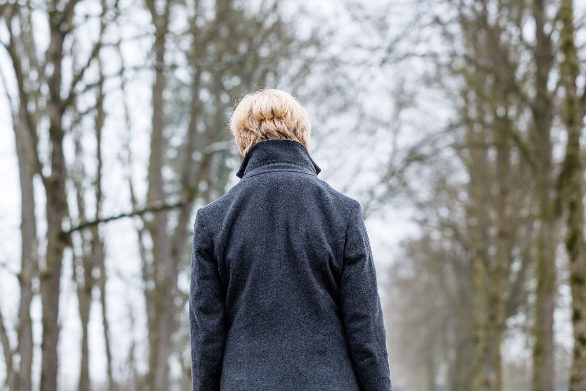 Woman walking in woods during winter.
